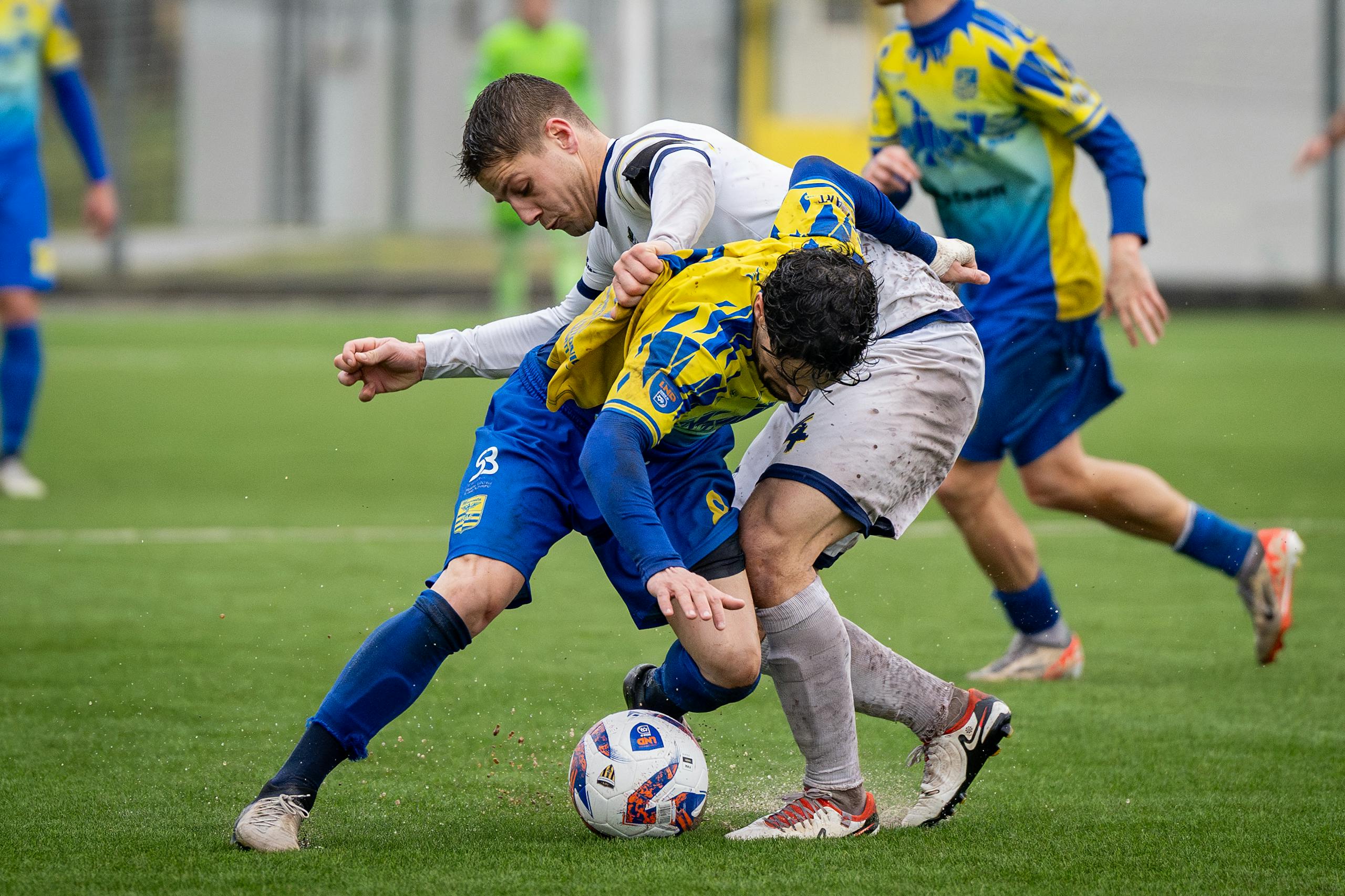 Close-up action shot of two soccer players tackling during an intense match.
