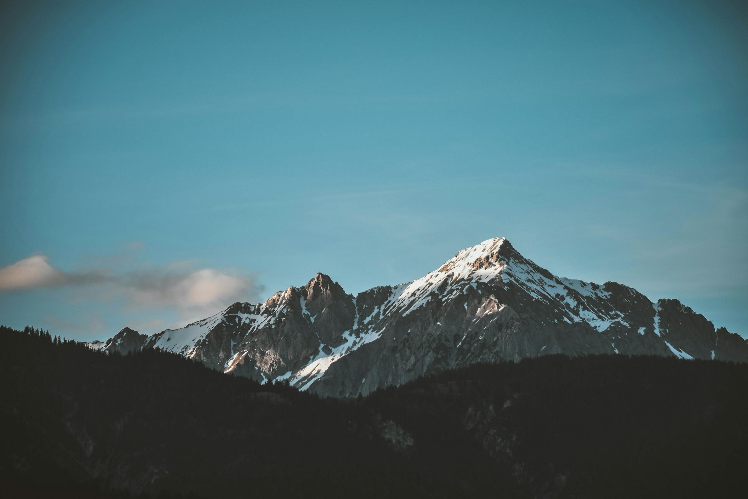 Stunning view of snow-capped mountains against a blue sky, perfect for nature lovers.